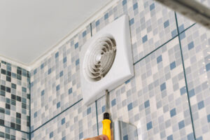 Electrician repairing faulty bathroom exhaust fan 