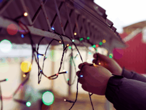 Man hanging Christmas lights outdoors