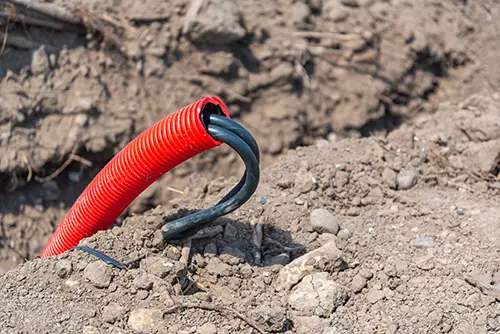 Damaged underground electrical conduit with exposed cables
