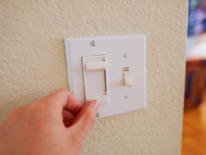 Homeowner adjusting failing dimmer switch