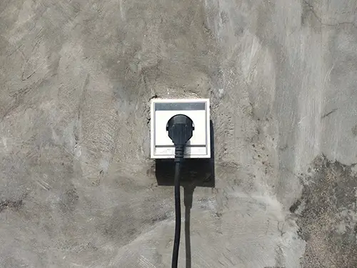 Exterior 220v electrical outlet with power cord plugged in