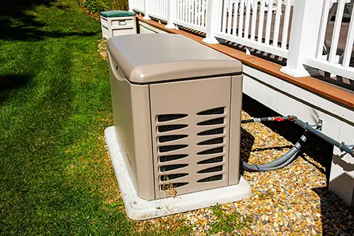 Residential standby generator installed outside a home with electrical transfer switch connection