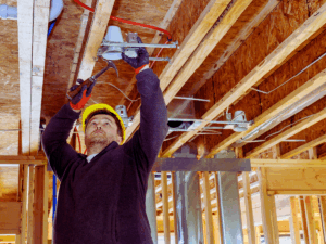 electrician installing recessed lighitng in new construction 